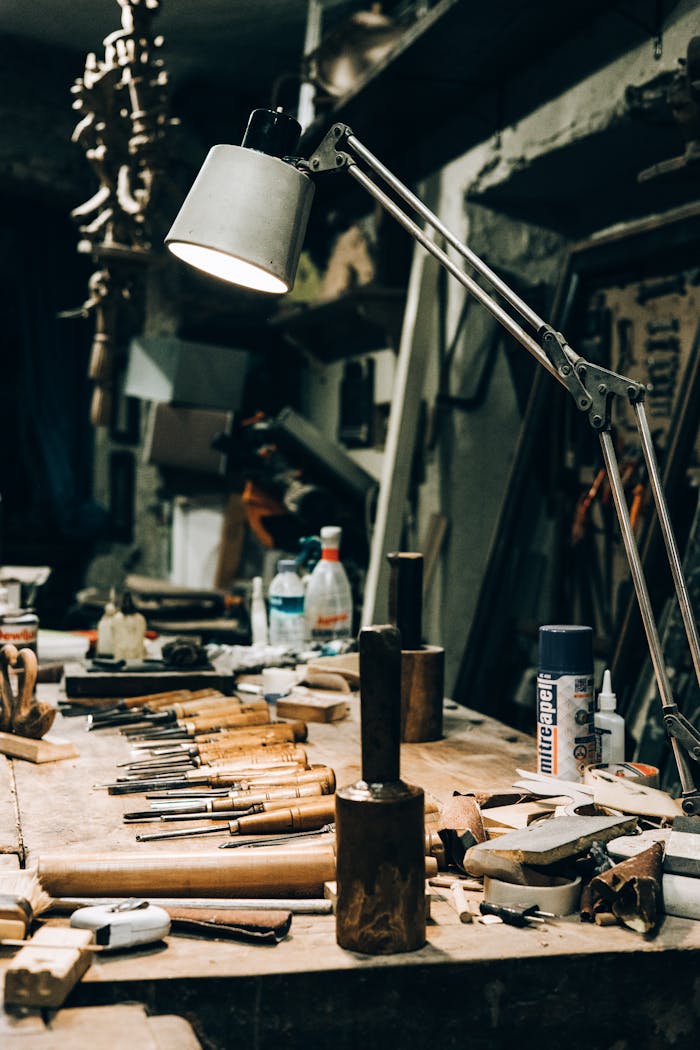 A warmly lit workshop with tools neatly arranged under a lamp.