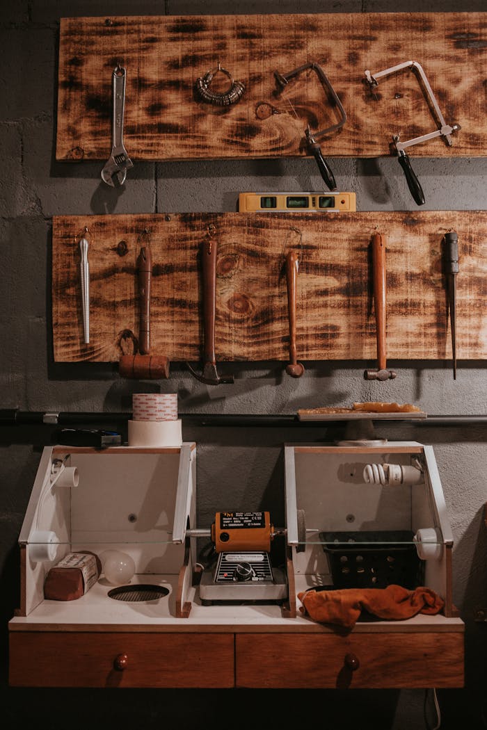 A collection of various tools neatly arranged in a workshop setting on a wooden pegboard.